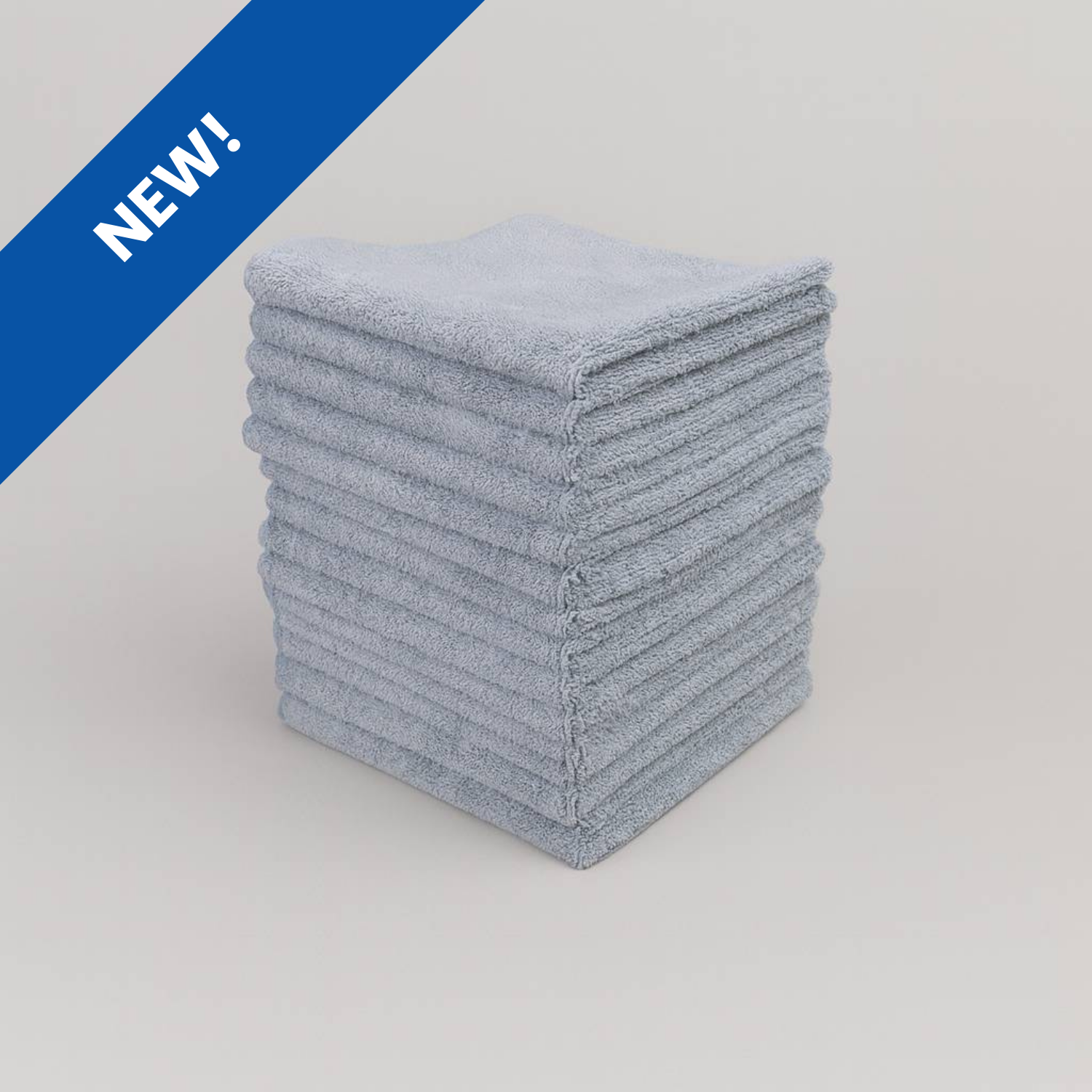 Stack of blue folded cloths on a light gray background with 'NEW!' label.