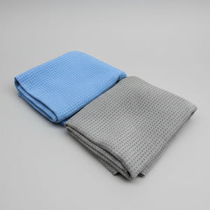 Two folded towels, one blue and one gray, on a white background