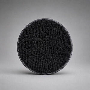 Black textured circular Pad on a gray background