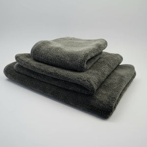 Set of three folded grey towels on a white background